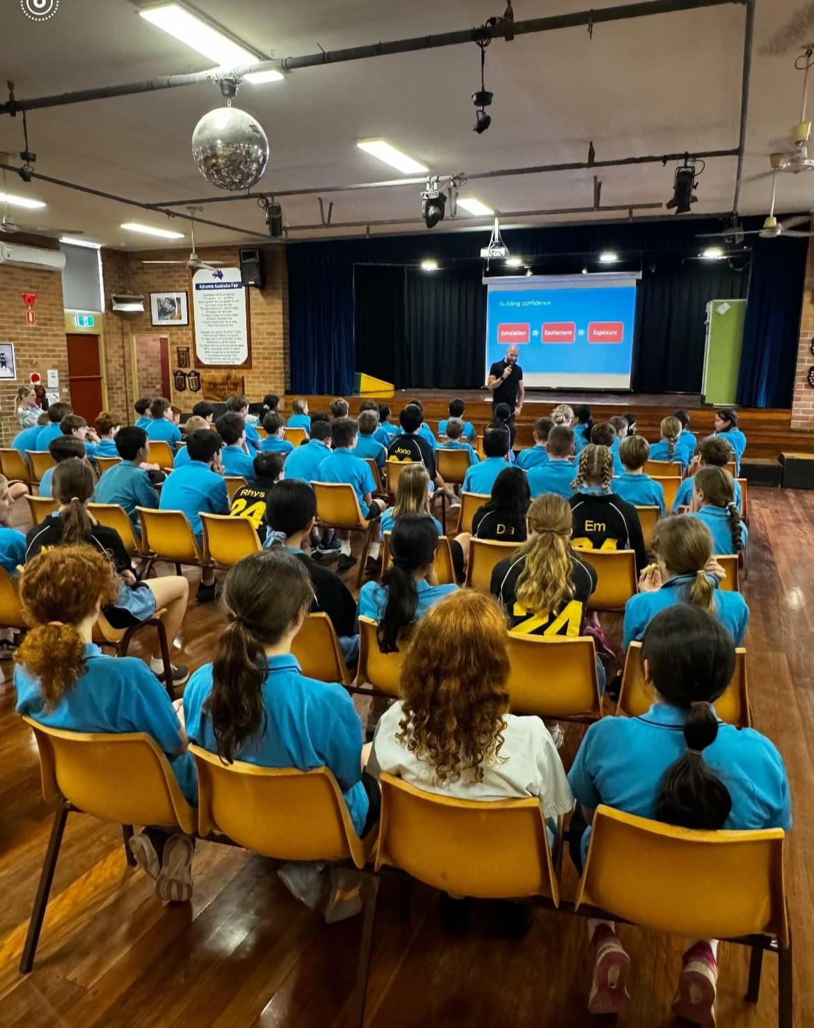 Nick Kenny presenting to primary school students seated in a school hall